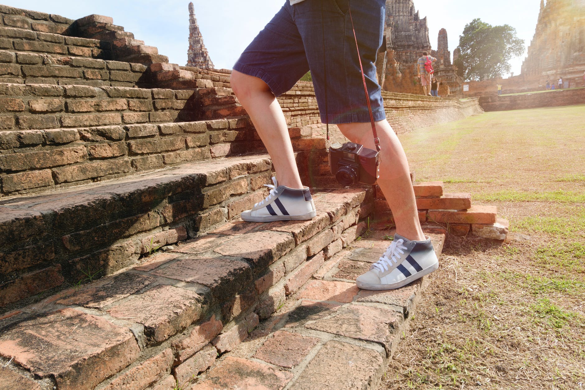 person wearing white and black mid rise sneakers at borobudur indonesia