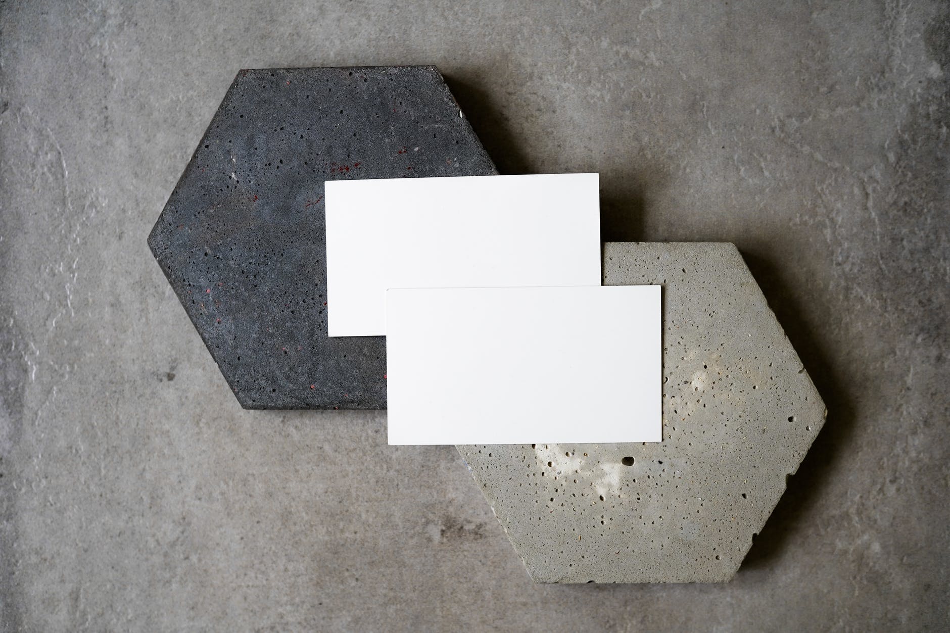 blank business cards on top of black and gray stones